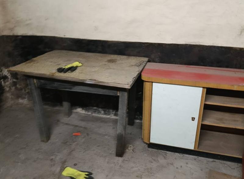 Kellerraum mit altem Tisch und Schrank während einer Räumung